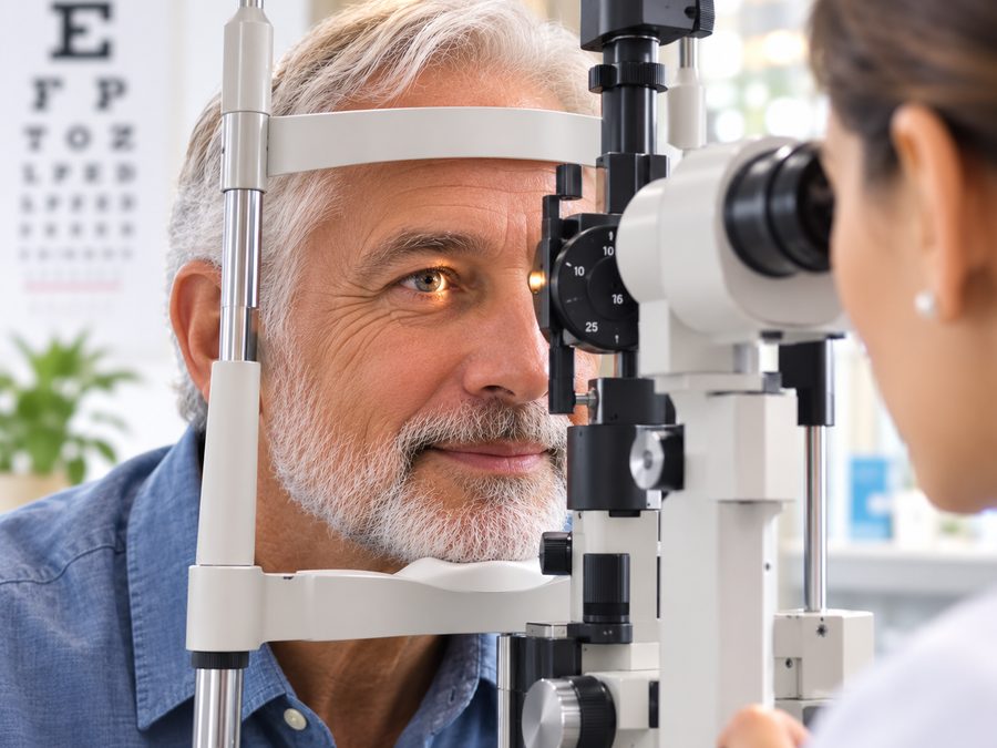 Optometrist examining a patient at a slit lamp